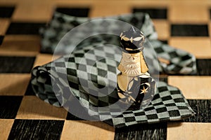 Pawn over necktie on chessboard