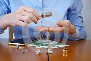 Pawn shop worker verify jewellery and photo or video camera and give money. Customers Buy and Sell Precious Metals, Jewels,