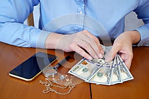 Pawn shop worker verify jewellery and photo or video camera and give money. Customers Buy and Sell Precious Metals, Jewels,