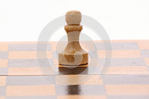 Pawn on a wooden chessboard