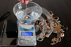 pawnshop worker determines the ring of gold jewelry using the Hydrostatic weighing method by Archimedes\' law