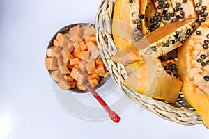 Pawpaw/Papaya in the cane fruit basket on wooden background.