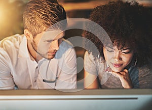 Always pay attention to detail. two young designers working together on a computer in the office.