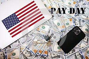 Pay day concept. USA flag, dollar money with keys, laptop and phone background