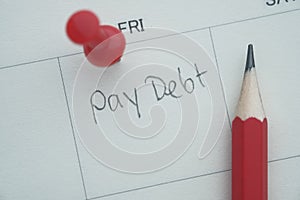 Pay debt word written on calendar, top view