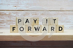 Pay It Forward alphabet letter on shelves wooden background