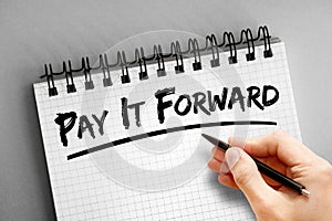 PAY IT FORWARD text on notepad, concept background