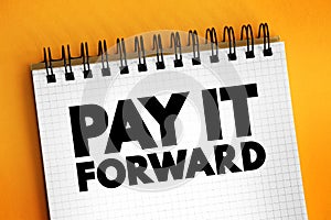 PAY IT FORWARD text on notepad, concept background