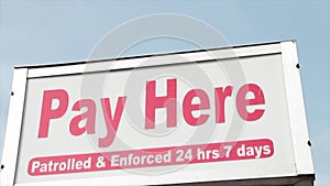 pay here patrolled and enforced 24 hours 7 days rectangle sign above pay meter..