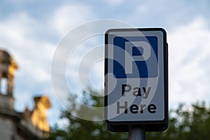 a pay here sign in a car park