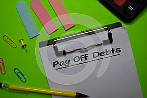 Pay Off Debts write on a paperwork isolated on Office Desk