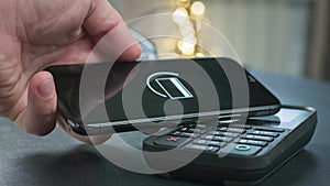 Pay by phone on the POS contactless payment terminal. A user makes a purchase using a smartphone in a store or