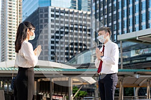 Pay respect is new novel greeting to avoid the spread of coronavirus. Two Asian young businessman and businesswoman meet in font