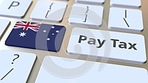 PAY TAX text and flag of Australia on the buttons on the computer keyboard. Taxation related conceptual 3D animation