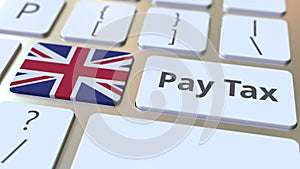 PAY TAX text and flag of Great Britain on the buttons on the computer keyboard. Taxation related conceptual 3D animation