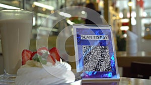 Pay touch-free with a QR code. QR code scanning app. Touchless digital payment option for businesses. A man sits in an