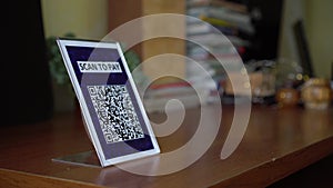 Pay touch-free with a QR code. QR code scanning app. Touchless digital payment option for businesses. A man sits in an