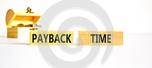 Payback time symbol. Concept words Payback time on wooden blocks. Beautiful white table white background. Wooden chest with coins