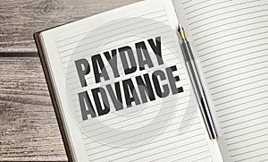 Payday Advance text on a notepad with pen, business