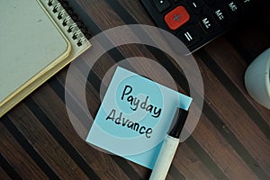 Payday Advance write on sticky notes isolated on Wooden Table