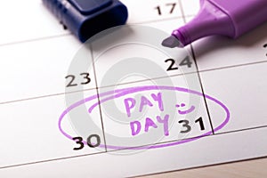 Payday concept calendar with marker and circled day of salary