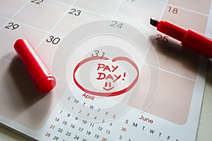Payday end of month date on calendar with red marker and circled day of salary