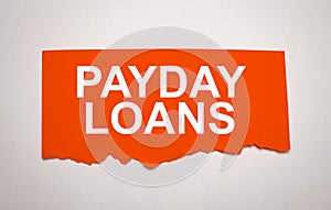 PAYDAY LOANS is written on a white sheet of paper