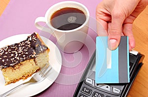 Paying with contactless credit card for cheesecake and coffee, finance concept