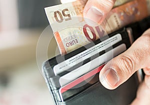 Paying with Euro bank notes from a black wallet