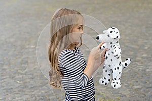 Paying is state of being. Little child play with toy dog outdoors. Role playing. Pretend play. Child development