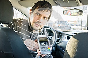 Paying for transportation. Taxi driver is offering payment terminal to customer