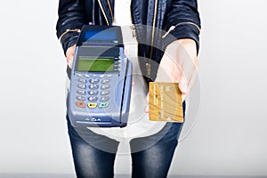 Payment card in a bank terminal. The concept of of electronic payment. Closeup of a woman hand holding credit card over