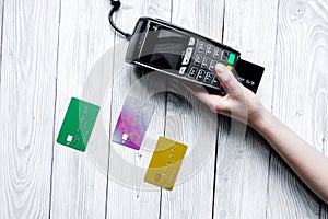 Payment card through terminal in store top view wooden background