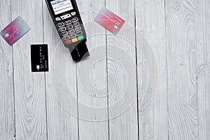 Payment card through terminal in store top view wooden background