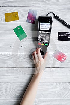 Payment card through terminal in store top view wooden background