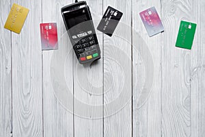Payment card through terminal in store top view wooden background