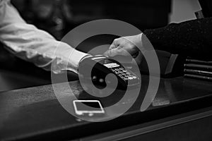 Payment with credit card. Male hand puts bankcard into reader