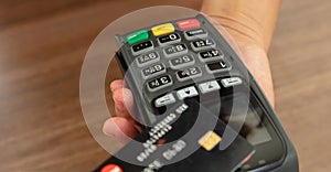 Payment machine, POS terminal and credit card on wooden background