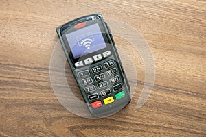 Payment machine, POS terminal on wooden background