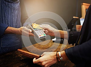 Payment made with just a single tap. a customer paying using NFC technology in a shop.