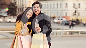 Payment and shopping online. Couple with credit card and bags
