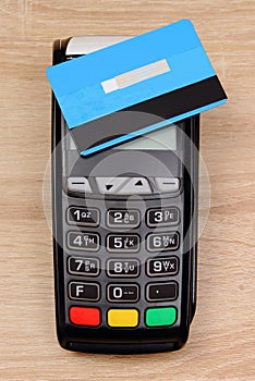 Payment terminal with contactless credit card on desk, finance concept