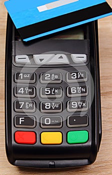 Payment terminal with contactless credit card on desk, finance concept