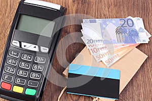 Payment terminal with credit card, currencies euro and paper shopping bag, paying for shopping concept