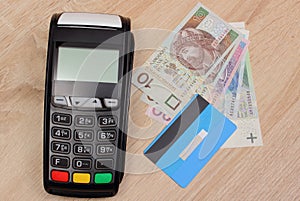 Payment terminal with credit card and polish money on desk, finance concept