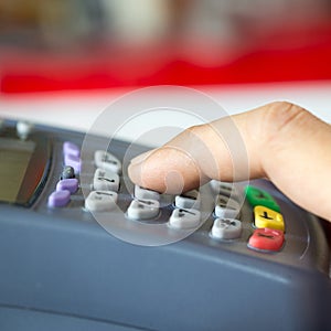 Payment terminal with keypad and a finger pressing on button