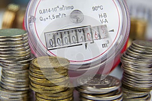 Payment for utilities. Water meter on the background of coins