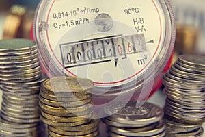 Payment for utilities. Water meter on the background of coins