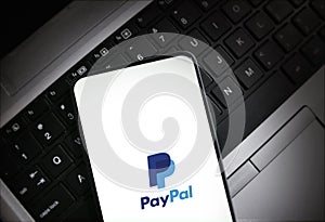 PayPal app displayed on smartphone over laptop keyboard illustrative editorial technology and finance