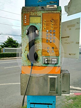 Payphone operated with coin old and rusty.
